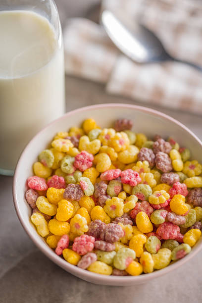 Colorful breakfast cereals in the shape of various fruit in bowl on a kitchen table.