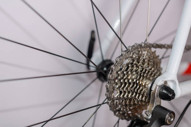 Detailed view of the rear gear mechanism and spokes of a white road bicycle. Highlights the intricacies of cycling equipment and mechanical engineering for enthusiasts and professionals.