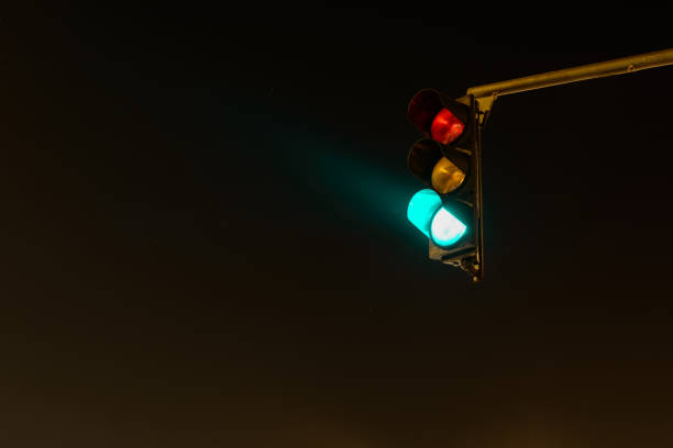 istock Traffic Light Showing Green Signal at Night on Dark Road 2194102049