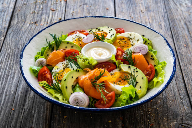 istock Smoked salmon with hard-boiled egg, avocado and leafy vegetables on wooden table 2194102133