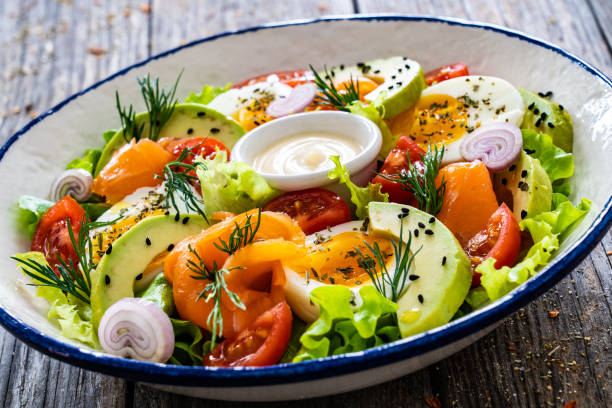 istock Smoked salmon with hard-boiled egg, avocado and leafy vegetables on wooden table 2194102191