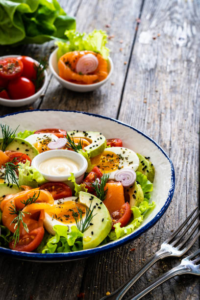 istock Smoked salmon with hard-boiled egg, avocado and leafy vegetables on wooden table 2194102212