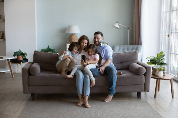 istock Happy millennial parents and two kids using mobile phone 2194102859