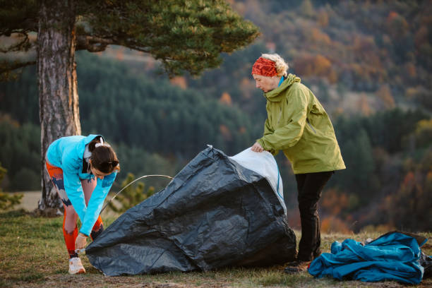 istock mom and daughter setting up a camp 2194107791
