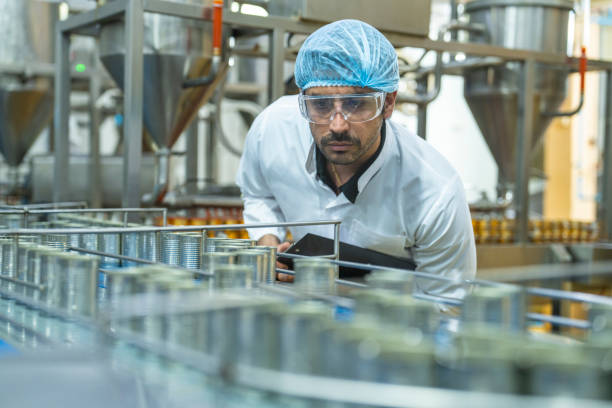 istock Professional closely examining production materials on a conveyor system, representing dedication to quality, precision, and modern technology in manufacturing processes. 2194113240
