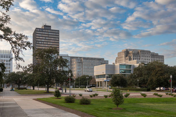 A view of downtown Baton Rouge, Louisiana, highlighting the blend of modern architecture and green public spaces under a partly cloudy sky.