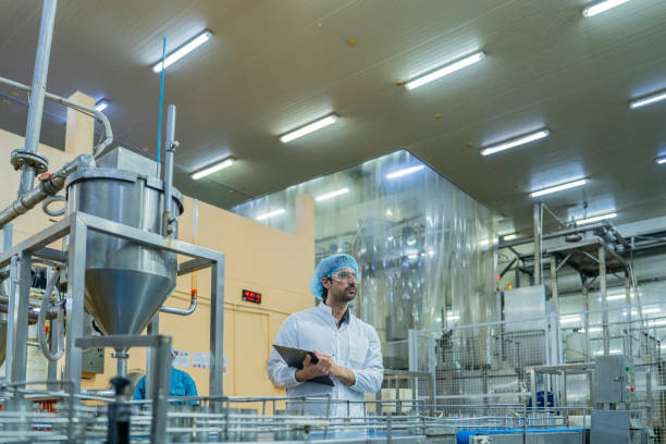 istock A quality control inspector monitors production at an automated food processing plant, using a clipboard for documentation. The scene highlights precision and efficiency in industrial manufacturing. 2194113275