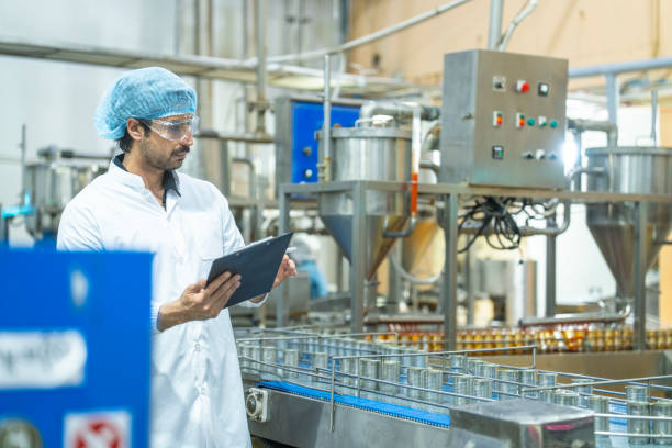 istock Industrial worker examining a product sample with a clipboard in hand, emphasizing precision, professionalism, and the importance of quality control in a modern factory environment. 2194115178