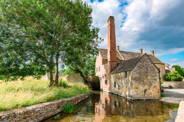 Old water mill reflecting on the eye river in lower slaughter, cotswolds, england