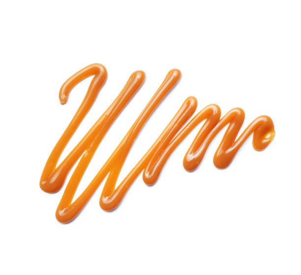 Pattern drawn with liquid caramel syrup close up isolated on a white background