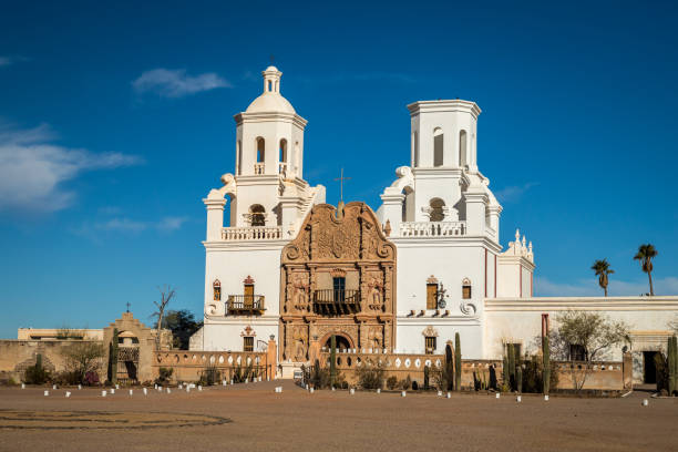 San Xavier del Bac Mission stands majestically in the Sonoran Desert, showcasing its stunning architecture against a clear blue sky.