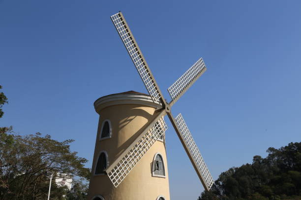 istock A large windmill with a white roof is standing in a field 2194127022