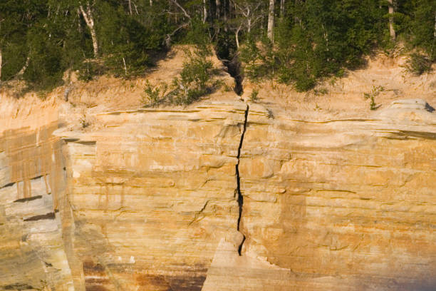 a crack in the rock lets light through in an x-shape. cracks in sandstone a block with a crack that you wedge yourself into but can't climb into. danger of getting stuck, v,