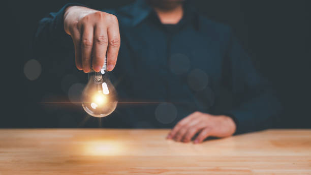 istock Person holding glowing light bulb represents creativity and innovation captivating image symbolizes new ideas and spark of inspiration that drives progress 2194140550