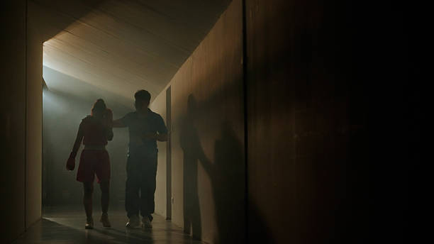 Boxer and coach walking and talking after fight match