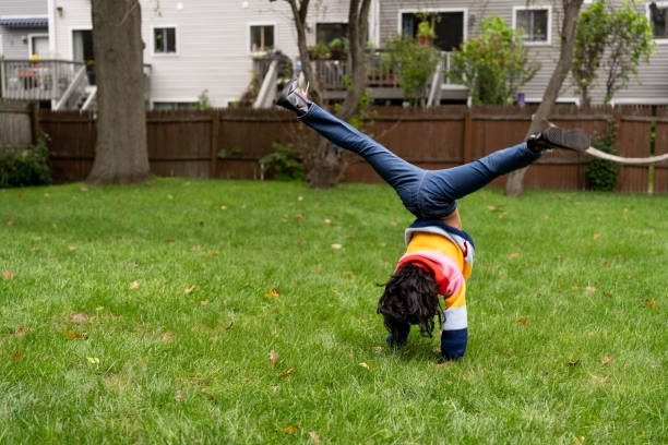 Playful black girl in the back yard in a grass area