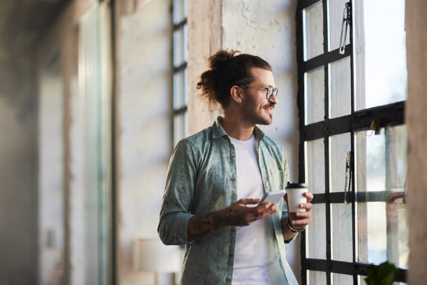 istock Happy freelancer using cell phone on coffee break by the window. 2194148422