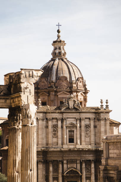 A detailed close-up of the dome of Santi Luca e Martina Church, framed by the timeless ruins of Roman columns. The intricate architectural details of the dome harmonize with the soft light of the day, evoking a sense of historical continuity.