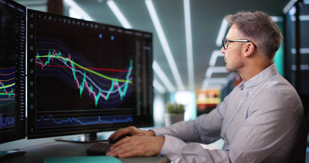 istock Stock Market Broker Looking At Graphs On Multiple Screens 2194154902