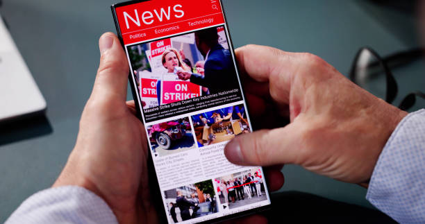 istock Watching Online News Article On Mobile Phone And Laptop 2194154965