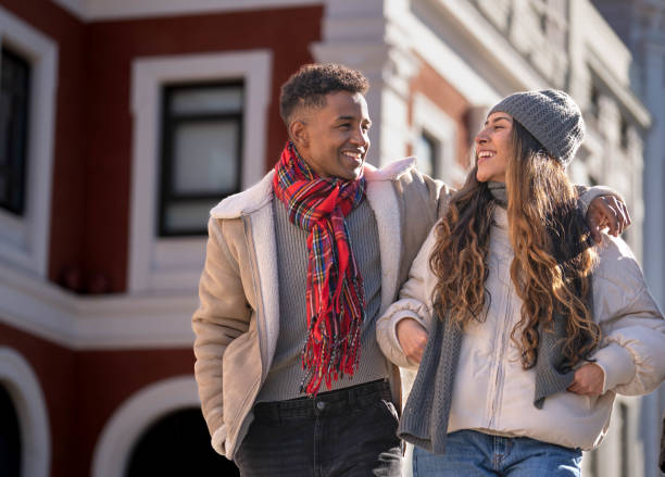 istock Happy multi-ethnic couple walking and smiling outdoors in winter clothes 2194158351
