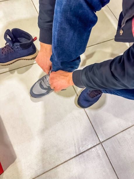 istock male Trying On grey Sneakers at a Shoe Store 2194160032