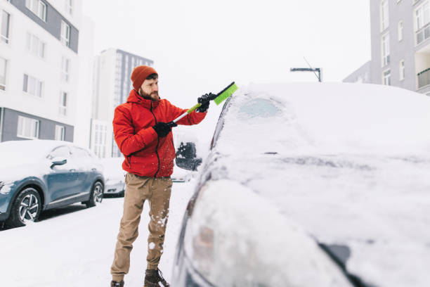 istock Man Clearing Snow from Car with Brush 2194160133