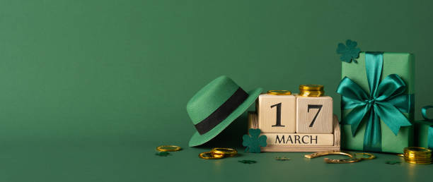 istock Green-themed side view St. Patrick's Day setup featuring a decorative hat, golden coins, and a wrapped present 2194161606
