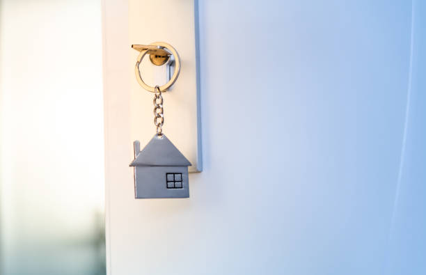 istock Open the door and door handle with a key and a house shaped silver keyring 2194166489