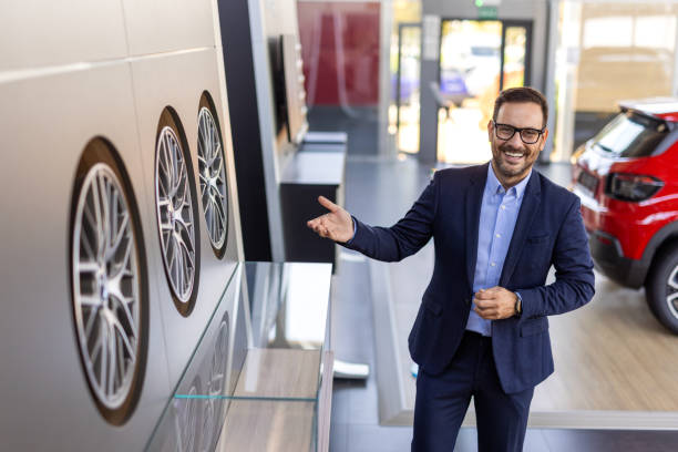 istock Car salesman showing customer rim sizes when buying car 2194166823