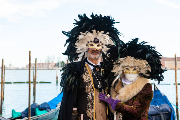 Venice,Italy-February 8th 2015:Masked people in picturesque colorful costumes, disguised persons at Saint Mark square during the Venice Carnival Opening Ceremony