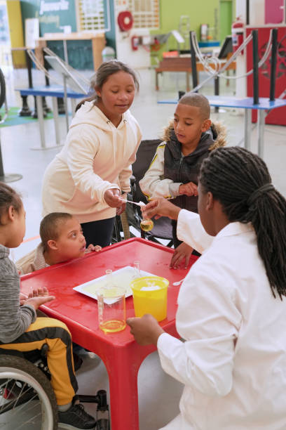 Diverse schoolchildren with teacher work together on science project
