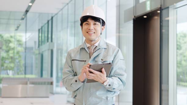 A man wearing work clothes working with a smile stock photo