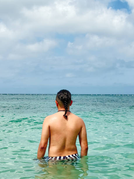Tourist enjoying refreshing turquoise water in idyllic ocean setting, perfect for summer getaway