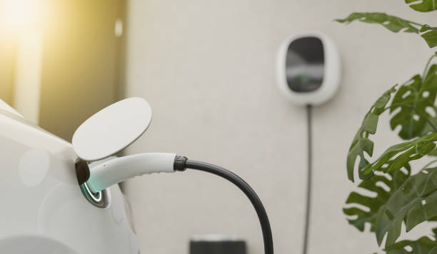 istock electric car charging with modern EV charger. EV charger is mounted on the wall 2194174236