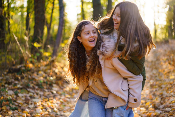 istock Girls having fun piggyback in the forest 2194176088