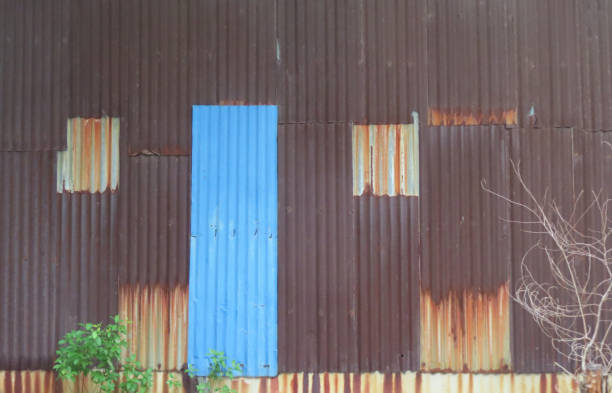The house wall is made of corrugated iron, consisting of both old and new sheets in various sizes The house wall is made of corrugated iron, consisting of both old and new sheets in various sizes, Bangkok, Thailand. corrugated metal fence ideas stock pictures, royalty-free photos & images