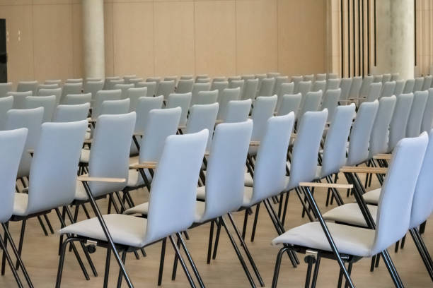 istock A row of light-colored chairs with wooden armrests. 2194178198