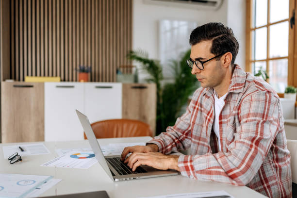 istock Casually clothed businessman using laptop at the office 2194178617