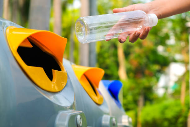 istock Woman's hand holding a water bottle and throwing plastic bottles into the trash for disposal. Types of plastic waste and recycling. environmental concept 2194178655