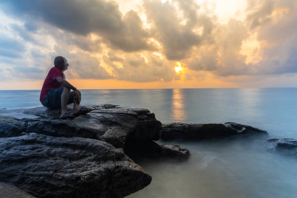 istock isolated old man illusion effect long exposure blur with dramatic sunrise sky over sea horizon 2194179511