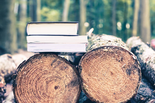 istock Paper books on fallen trees, the concept of the problem of forest conservation and tree felling for industrial paper production 2194181232