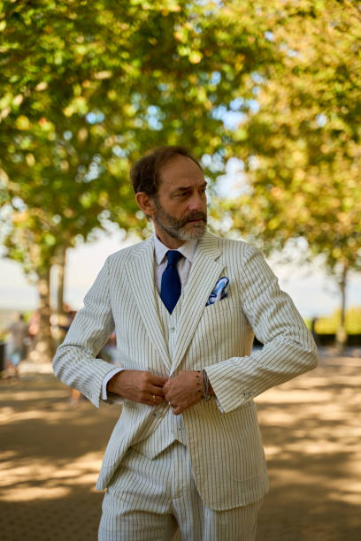 istock Caucasian man over 50 adjusting striped suit jacket in sunny park 2194182683