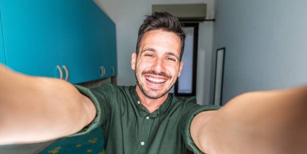istock Handsome young man taking selfie pic with smart mobile phone indoor - Smiling guy looking at camera at home - People and technology concept 2194186347