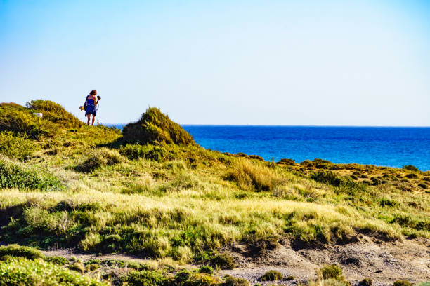 istock Woman walk on seashore, take photo with camera 2194186521