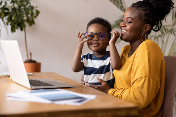 Mother and son having fun with eyeglasses while working from home