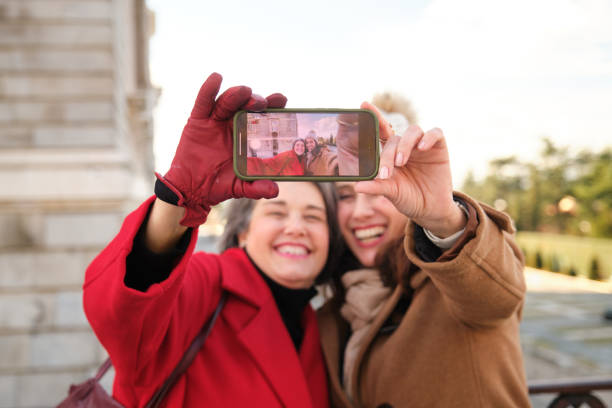 istock Two smiling women taking a selfie with smartphone in urban environment 2194189417