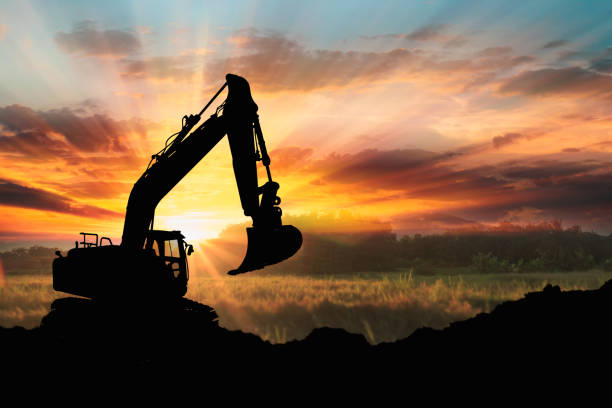 istock Excavators are digging the soil in the construction site on the sunset background, 2194190786
