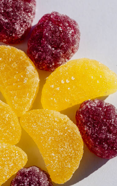 Yellow and purple gummy candies on white background