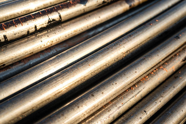 Stack of pipeline of tubing pipe in dirty condition that used in the oil production industrial. Close-up and selective at the object.